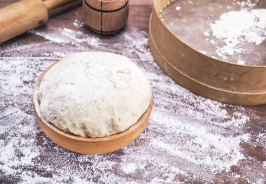 bir tablo üzerinde ahşap bir kapta buğday unu hamur yapılmış