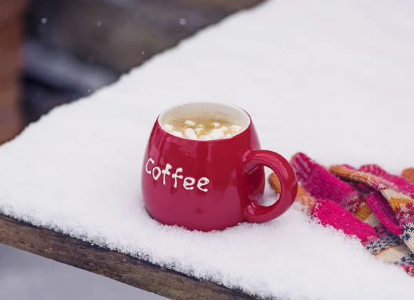 Luvas de malha e uma xícara vermelha com café — Fotografia de Stock