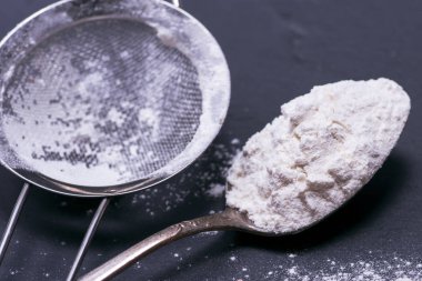 bir demir kaşık beyaz buğday unu 