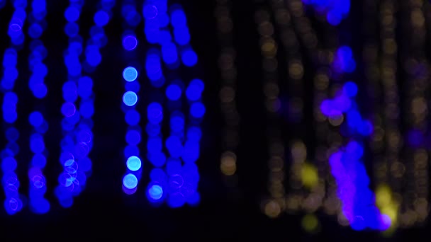 guirlandes lumineuses bleues et jaunes à l'extérieur se concentrent sur la rue, nuit d'hiver 