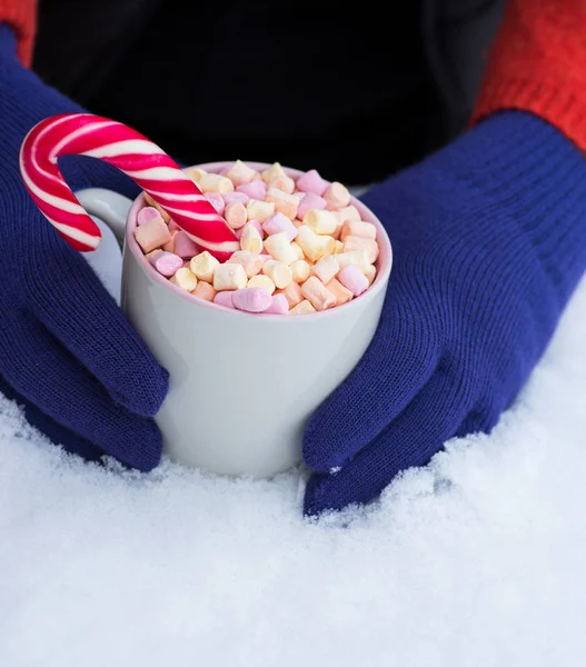Female hands in blue mittens hold a cup of hot chocolate — Stock Photo, Image