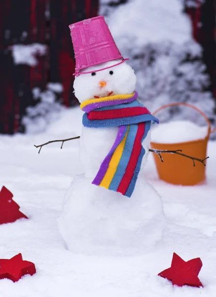 Sneeuwpop met een emmer op zijn hoofd op witte sneeuw — Stockfoto