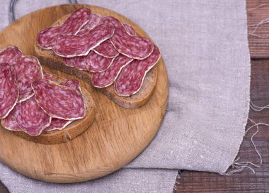 Tütsülenmiş sosis salam siyah ekmek üzerinde parçaları