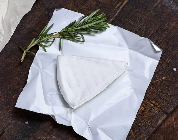 Trozo de queso brie sobre papel — Foto de Stock