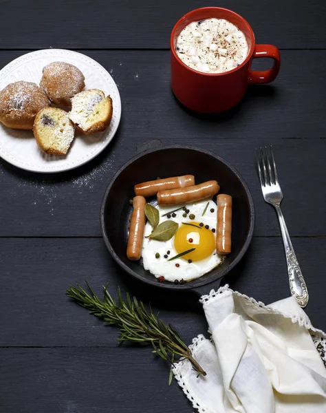 Egg with sausages in a black frying pan, cocoa with marshmallows — Stock Photo, Image