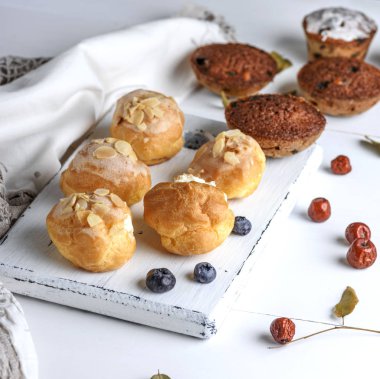 Pişmiş beyaz krema ile yuvarlak profiterol ve Baron Mavi Sakal ile cupcakes