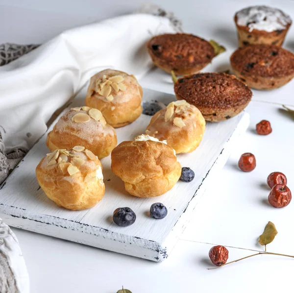 Pişmiş beyaz krema ile yuvarlak profiterol ve Baron Mavi Sakal ile cupcakes