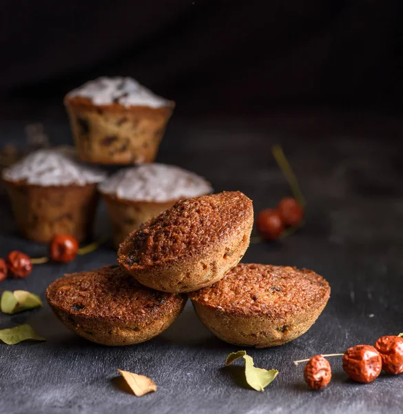 Gebackene runde Muffins mit einem schwarzen Holztisch aus Rosinen — Stockfoto