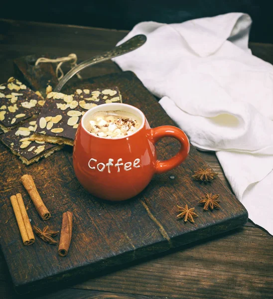 Mug keramik merah dengan kopi di latar belakang kayu cokelat — Stok Foto
