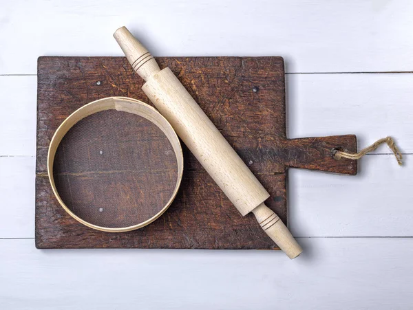 empty rectangular metal pan and rolls of brown parchment paper