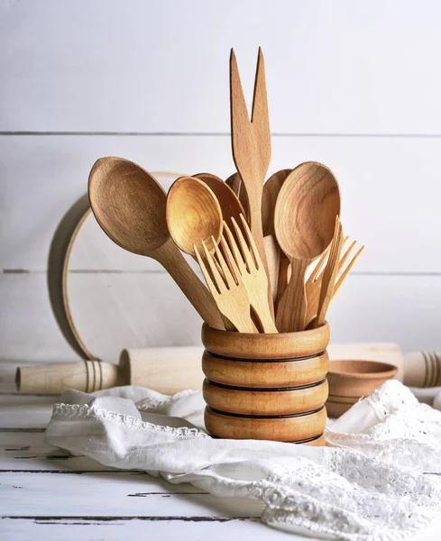 Cucharas y tenedores de madera en un recipiente de madera — Foto de Stock