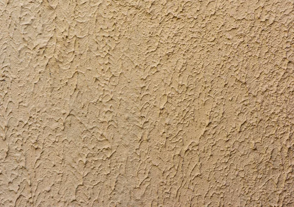 Fragment van beige muur met decoratieve pleister van golven — Stockfoto