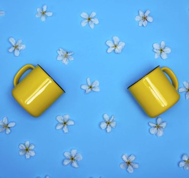 mavi bir arka plan üzerinde iki sarı seramik kupalar 