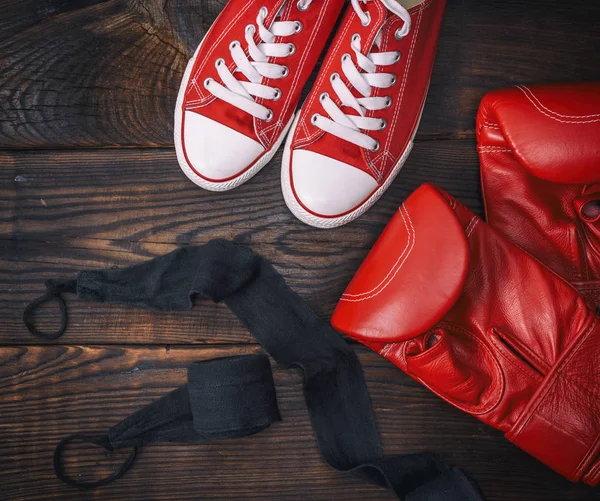 Luvas de boxe de couro vermelho e tênis têxteis — Fotografia de Stock