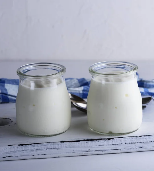 Hausgemachter Joghurt in einem Glas auf einem weißen Holzbrett — Stockfoto