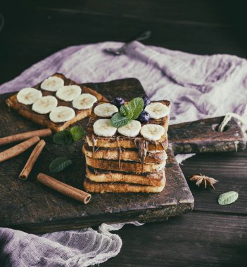 kare kızarmış ekmek dilimleri ile çikolata ve muz dilim yığını