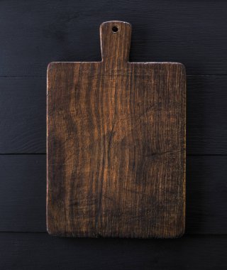 çok eski kahverengi mutfak kesme tahtası saplı, yakın çekim, siyah ahşap arka plan
