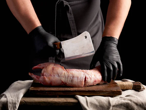 Chef in black latex gloves holds a big knife and cuts into piece — Stock Photo, Image