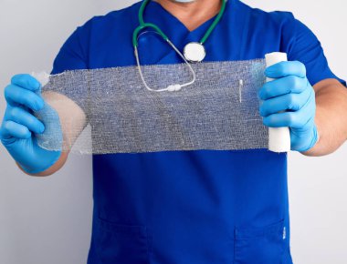 Mavi üniformalı doktor ve lateks eldivenli doktor bir rulo beyaz...
