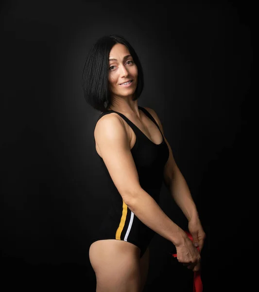 young woman gymnast of Caucasian appearance with black hair spin