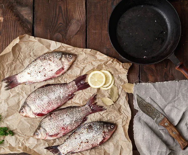 Färsk korsfisk beströdd med kryddor ligger på brun smulad — Stockfoto
