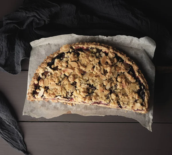 Moitié plum pie crumble sur une planche à découper en bois marron — Photo