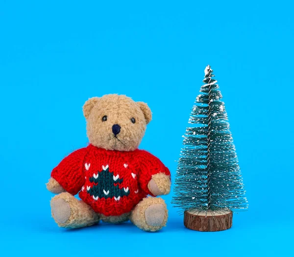 Piccolo orsacchiotto in un maglione rosso di Natale e una tr decorativa — Foto Stock