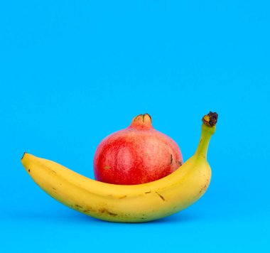 Olgun kırmızı nar ve kabukta sarı muz. 