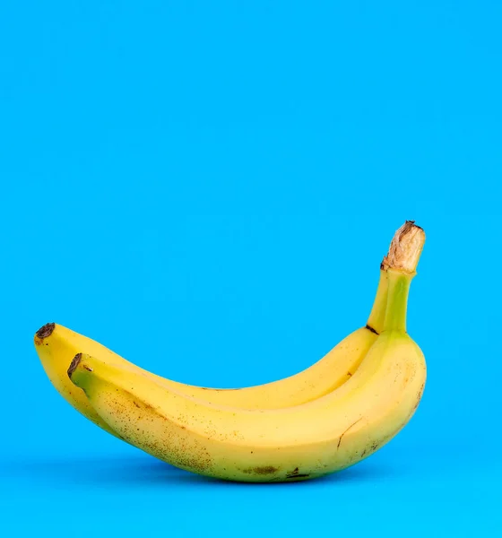 Ripe yellow banana on a blue background, copy space — Stock Photo, Image