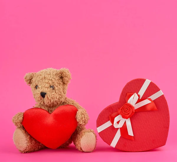 Cute brown teddy bear holding a big red heart and red box — Stock Photo, Image