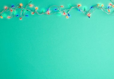 Renkli ışıklarla beyaz bir telde Noel çelengi yakmak