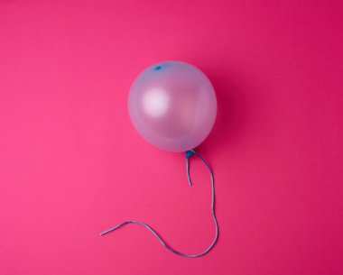 Pembe arka planda şişirilmiş mavi kauçuk balon