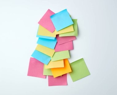 Beyaz arkaplanda çok renkli kağıt kare etiketleri yığını