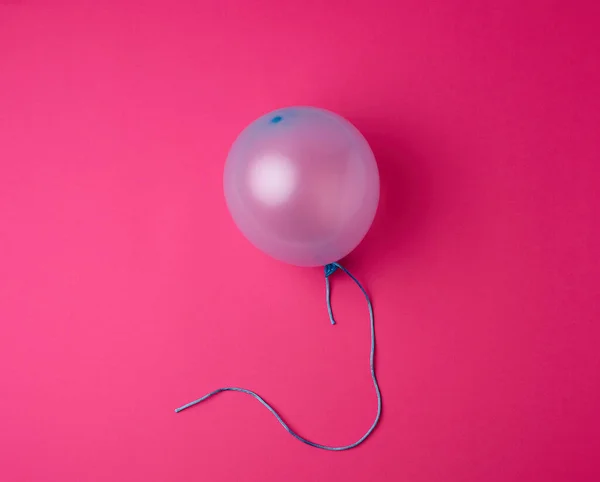 Globo de goma azul inflado sobre un fondo rosa — Foto de Stock