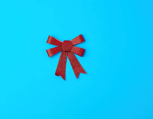 Red shiny bow for decoration gifts on a blue background — ストック写真