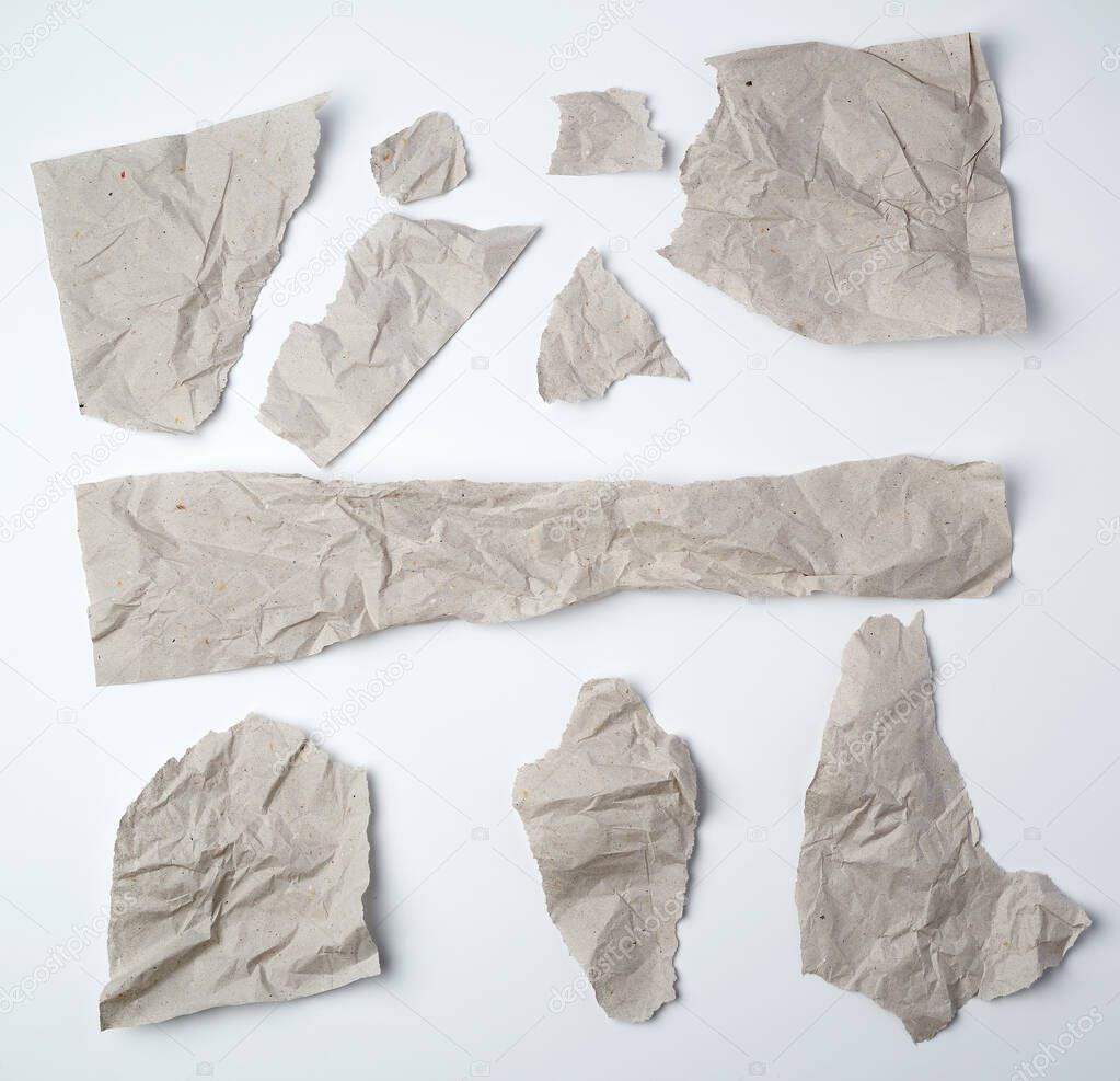 set of various pieces of torn gray crumpled paper on a white bac