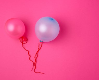 Pembe arka planda şişirilmiş mavi ve pembe kauçuk balonlar