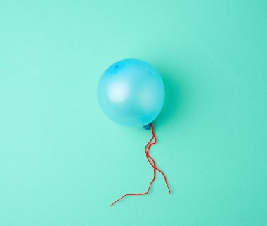 Yeşil arka planda şişmiş mavi kauçuk balon