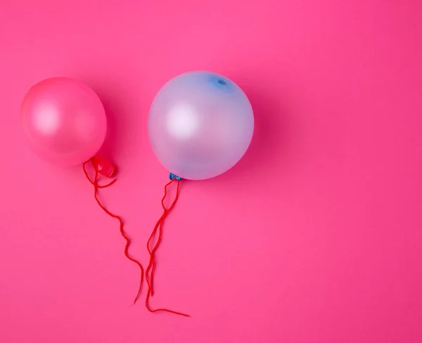 Globos inflados de goma azul y rosa sobre un fondo rosa — Foto de Stock