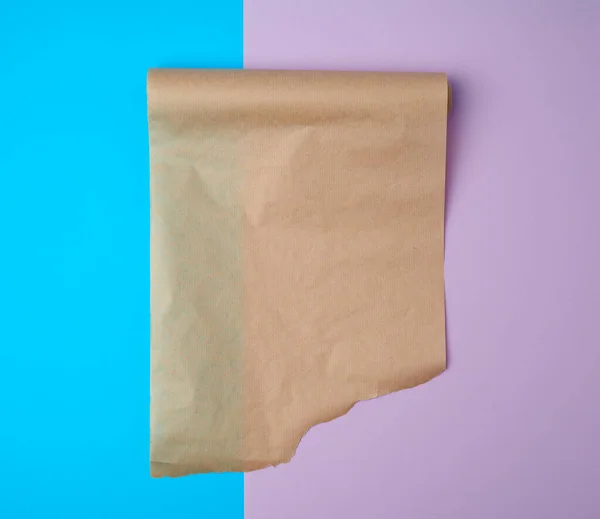 Kicsomagolt egy tekercs barna pergamen papír egy színes backgroun — Stock Fotó