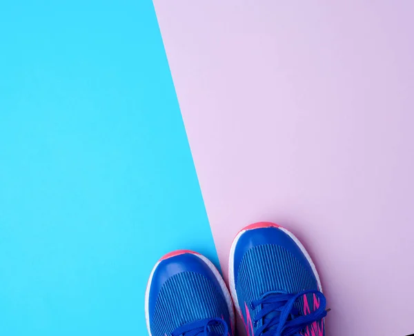 Para tenisówek sportowych z niebieskimi sznurowadłami na kolorowym abstrakcyjnym ba — Zdjęcie stockowe