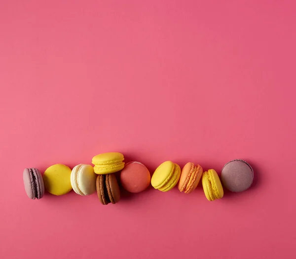 Macarons ronds multicolores cuits au four avec de la crème se trouvent dans une ligne — Photo