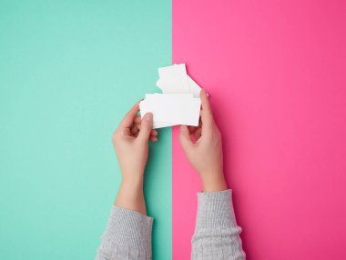 İki kadın eli boş bir kağıt yığınını tutuyor.