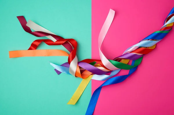 Muchas cintas multicolores de seda sobre un fondo de color — Foto de Stock