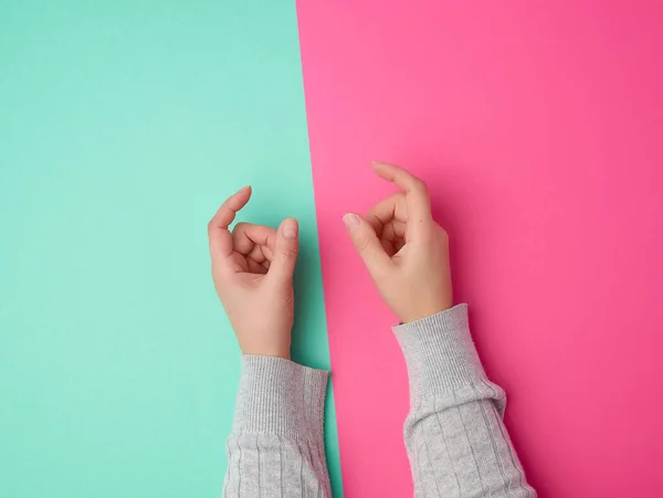 Ženské ruce na zeleném růžovém pozadí, prsty v gestu — Stock fotografie
