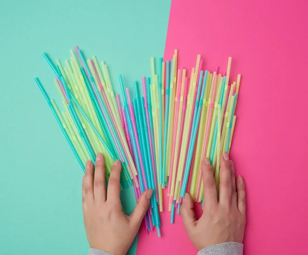 Female hand holding multicolored plastic cocktail tubes — Stock Photo, Image