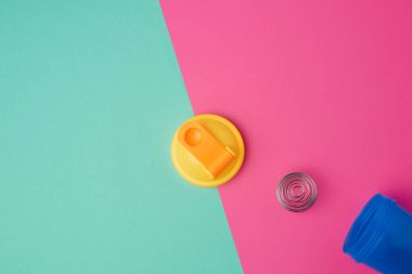 Sarı şapkası ve demir topu olan mavi plastik bir şişe.