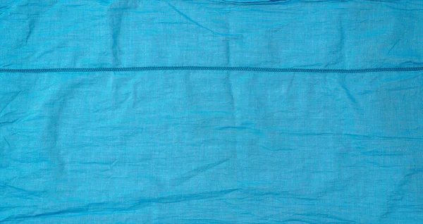 Fragment de tissu de coton bleu avec une couture, plein cadre — Photo