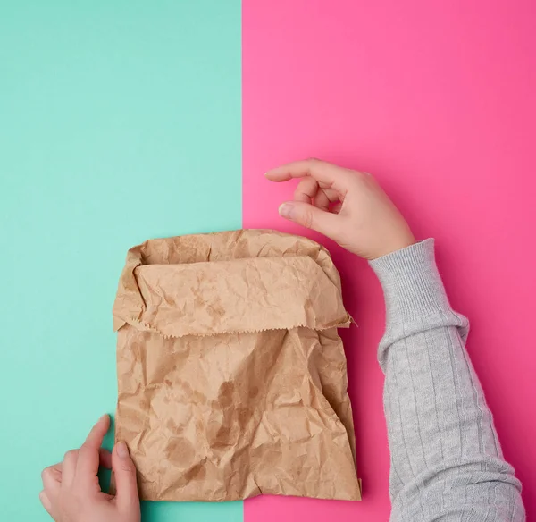 Dos manos femeninas sosteniendo bolsa de papel marrón abierta para envasado de alimentos —  Fotos de Stock