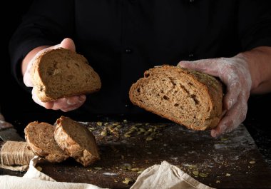 siyah üniformalı şef pişmiş ekmek bir parça kesilir tutar 